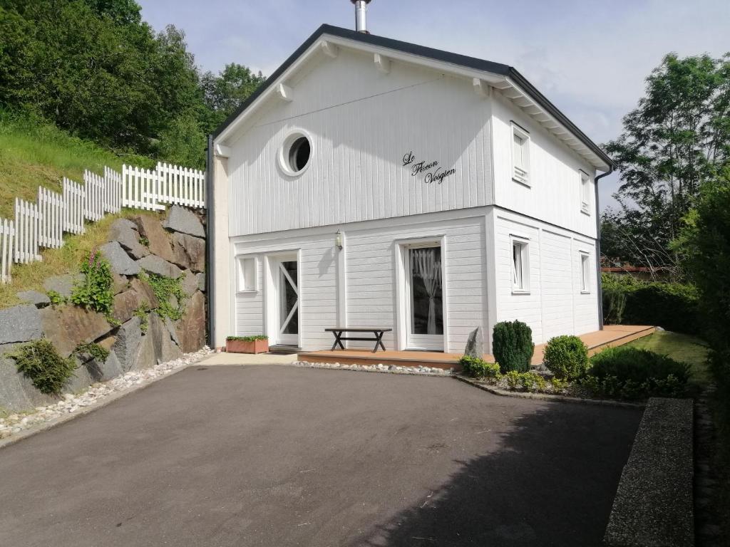 una iglesia blanca con un banco delante de ella en Le Flocon Vosgien, en Le Tholy
