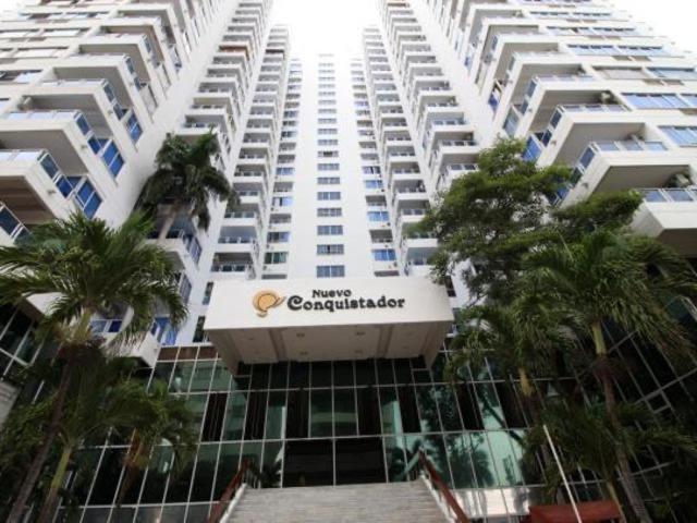 a large white apartment building with palm trees in front of it at Apartamento en el Laguito Cartagena in Cartagena de Indias