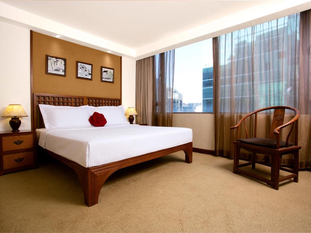 a bedroom with a bed and a chair and a window at Butterfly on Wellington, Central in Hong Kong