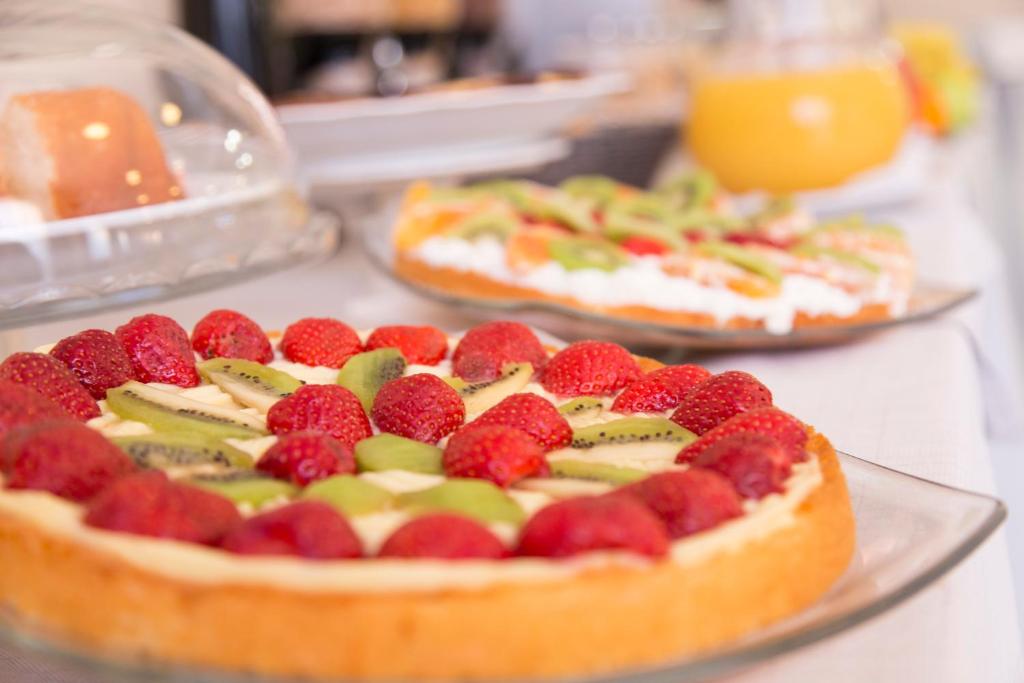 two pizzas with strawberries and kiwis on a counter at Hotel Fidenza in Fidenza