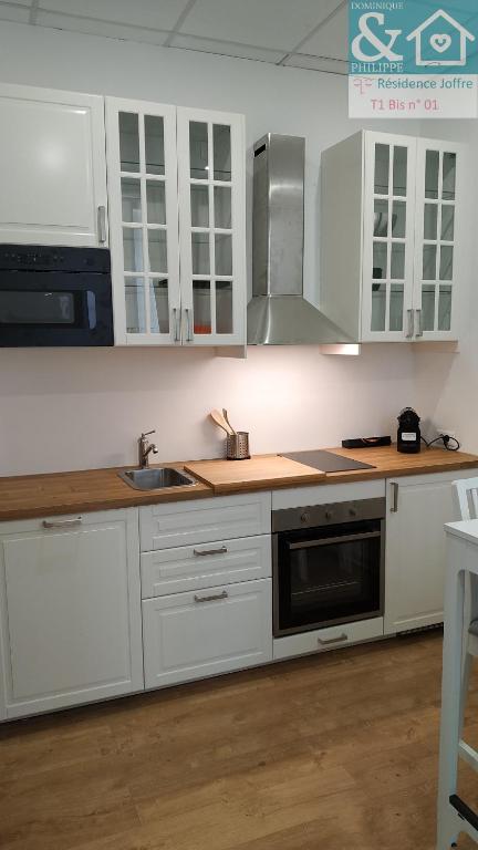 une cuisine avec des armoires blanches et un évier dans l'établissement T1 Bis neuf climatisé tout équipé #1, à Toulon