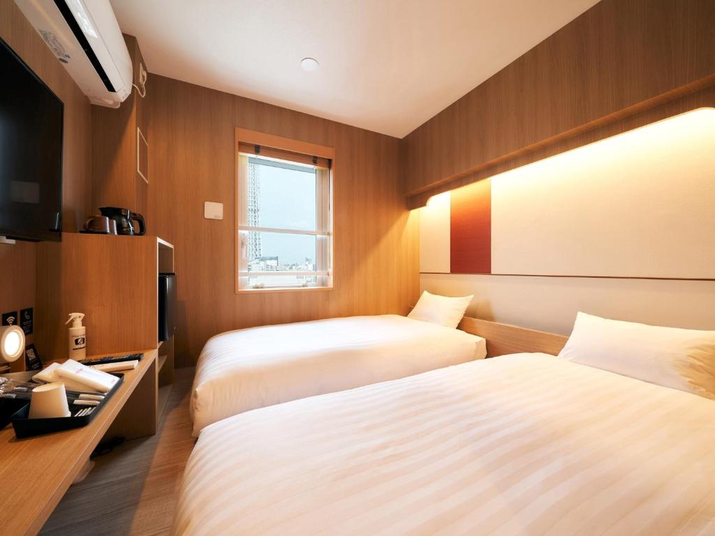 um quarto de hotel com duas camas e uma televisão em Rakuten STAY Tokyo Asakusa Twin Room with Unit Bath em Tóquio