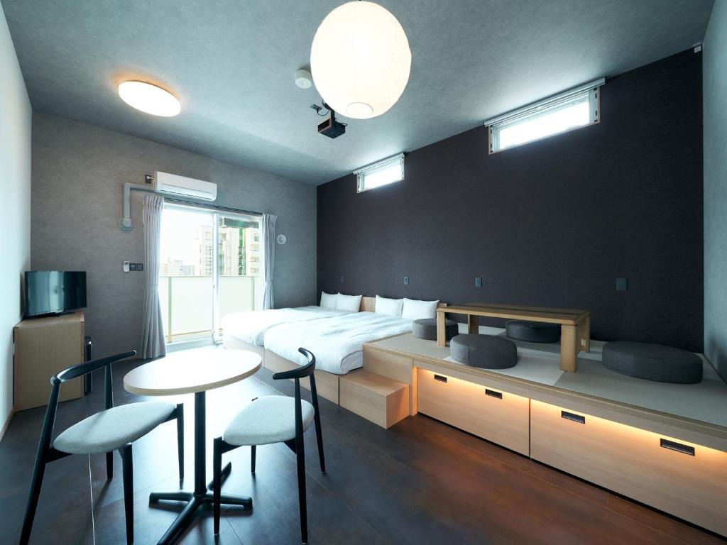 um quarto com uma cama, uma mesa e cadeiras em Rakuten STAY Hakata Gion 401 Superior Room em Fukuoka