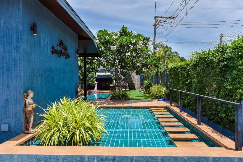 - une piscine à côté d'une maison bleue dans l'établissement Emmy pool villa-1(Cha-am), à Cha Am