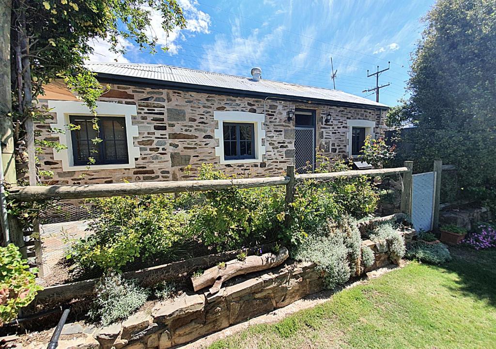 a stone house with a fence in front of it at Griffiths Cottage in Burra