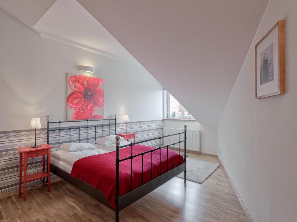 a bedroom with a red bed with a red blanket at Beauty of Krakow Apartment in Krakow