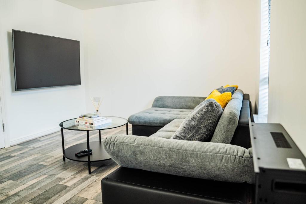 a living room with a couch and a tv at JB Apartments, Fully Equiped Ground Floor Apartment in Abbey Wood