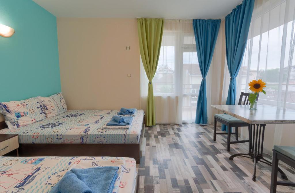 キテンにあるKazlarov Guest Houseのベッド2台、テーブル、デスクが備わる客室です。