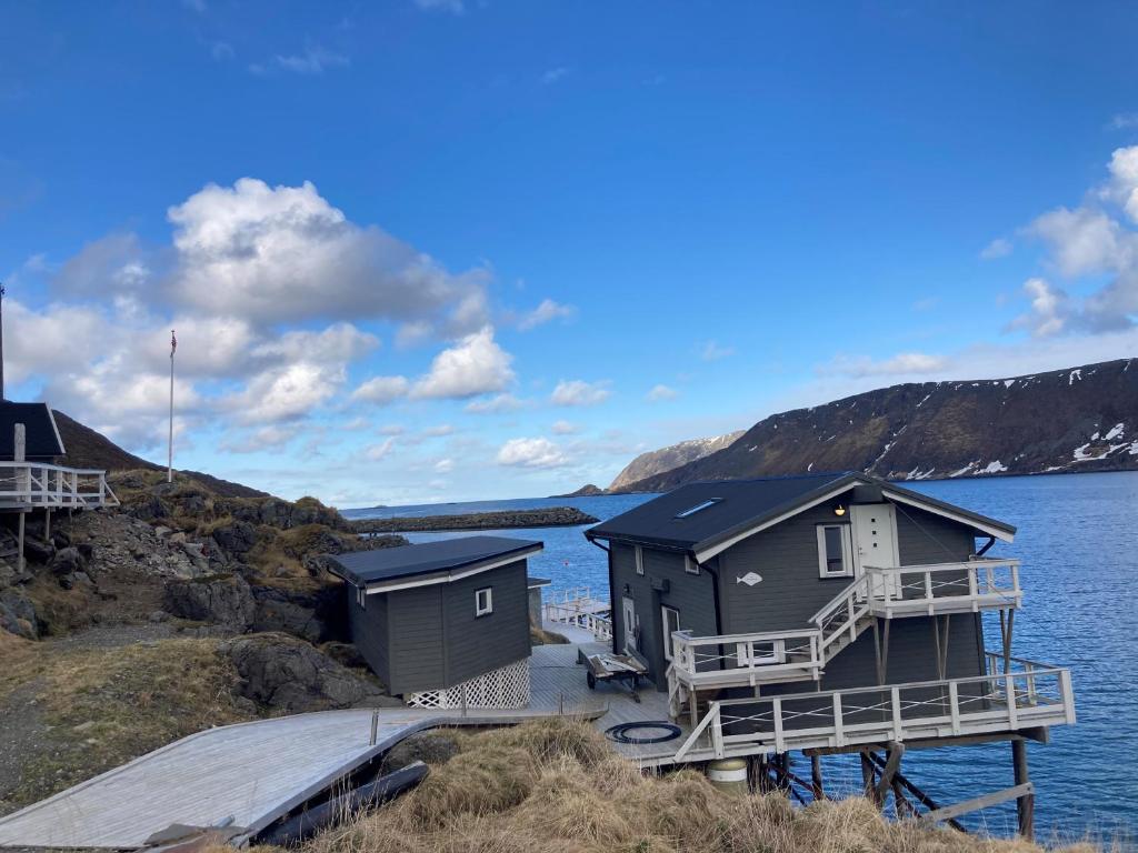 un paio di case sulla riva di un corpo d'acqua di Cape Marina Penthouse a Skarsvåg