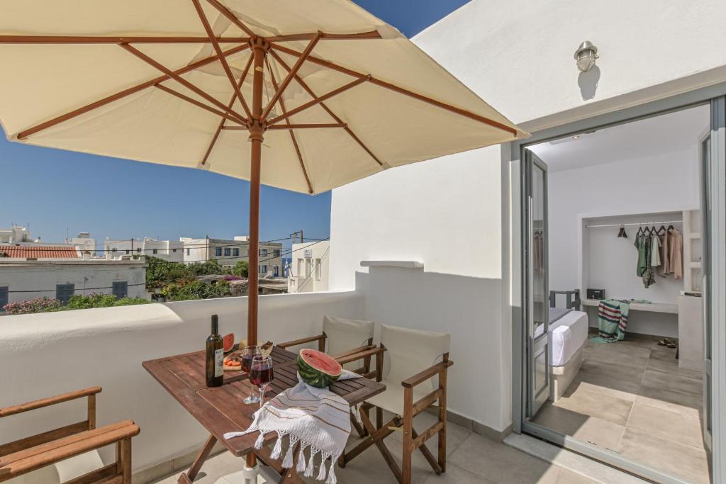 a patio with a wooden table and an umbrella at Venetian Suites II in Naxos Chora