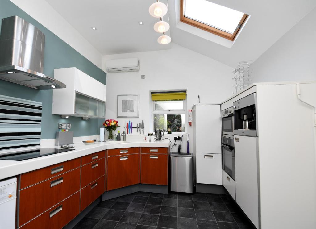 a kitchen with white appliances and brown cabinets at Harrogate Self Catering - Mews Suite - Garden in Harrogate