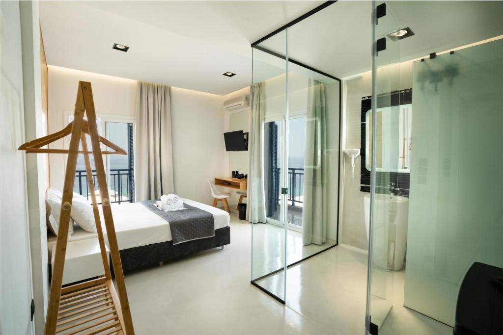 1 dormitorio con 1 cama y pared de cristal en Vrachos Lofts, en Afitos