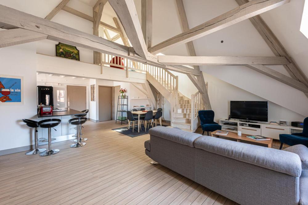 a living room with a couch and a table and a kitchen at Le Palais in Dijon