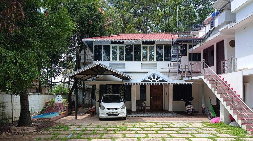 a white car parked in front of a house at Blue Birds Homestay in Cherai Beach