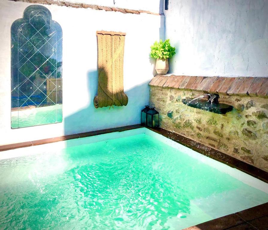 uma piscina numa casa com um lavatório em Casa del Cerro em Pedroche