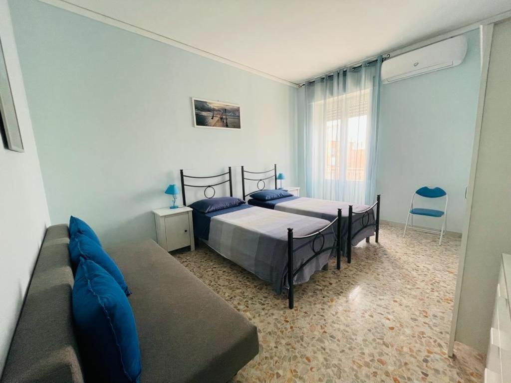 1 dormitorio con 2 camas y sofá en Sassi Planet, en Matera