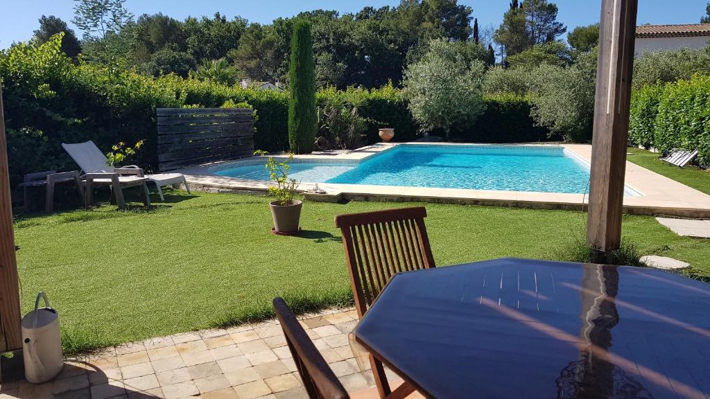 a table and chairs next to a swimming pool at Chambre chez l'habitant pour personnes en mission, just person on mission in Mougins
