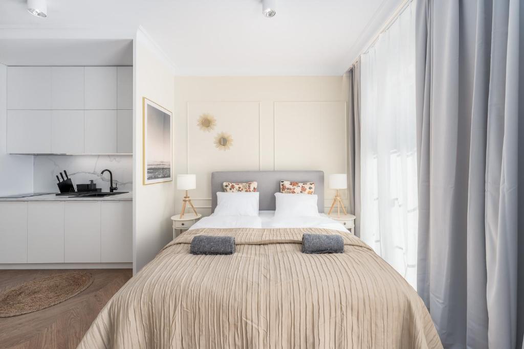 ein weißes Schlafzimmer mit einem großen Bett mit zwei Kissen in der Unterkunft Villa 44 in Świnoujście