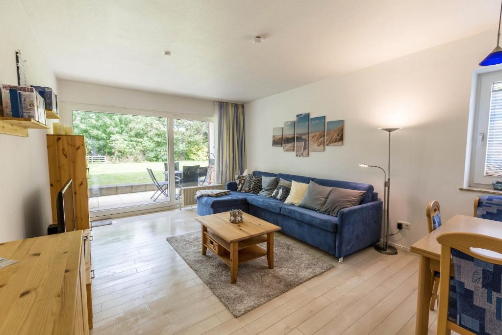 a living room with a blue couch and a table at Villa Anna ll App 73 in Sankt Peter-Ording