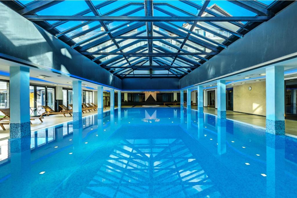 a large swimming pool with a glass ceiling at Saint George Palace Aparthotel in Bansko