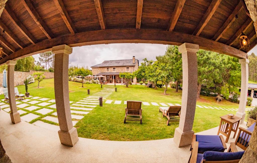 an outdoor pavilion with chairs and a house at Casa do Mudo in Cervo