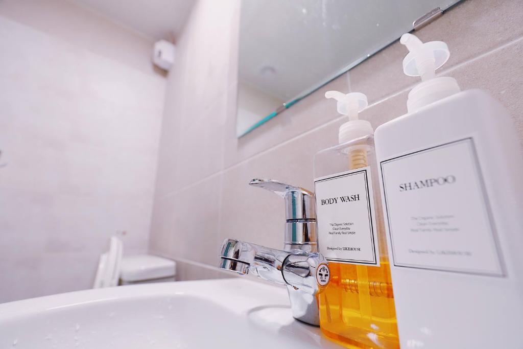 a bottle of soap sitting on a bathroom sink at Fully Mini Hotel in Seoul