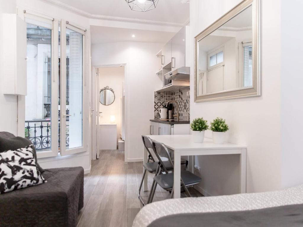 un salon blanc avec une table et un canapé dans l'établissement Montmartre Apartments Matisse, à Paris