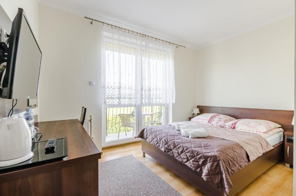 1 dormitorio con cama y ventana grande en Ramzes, en Ustka