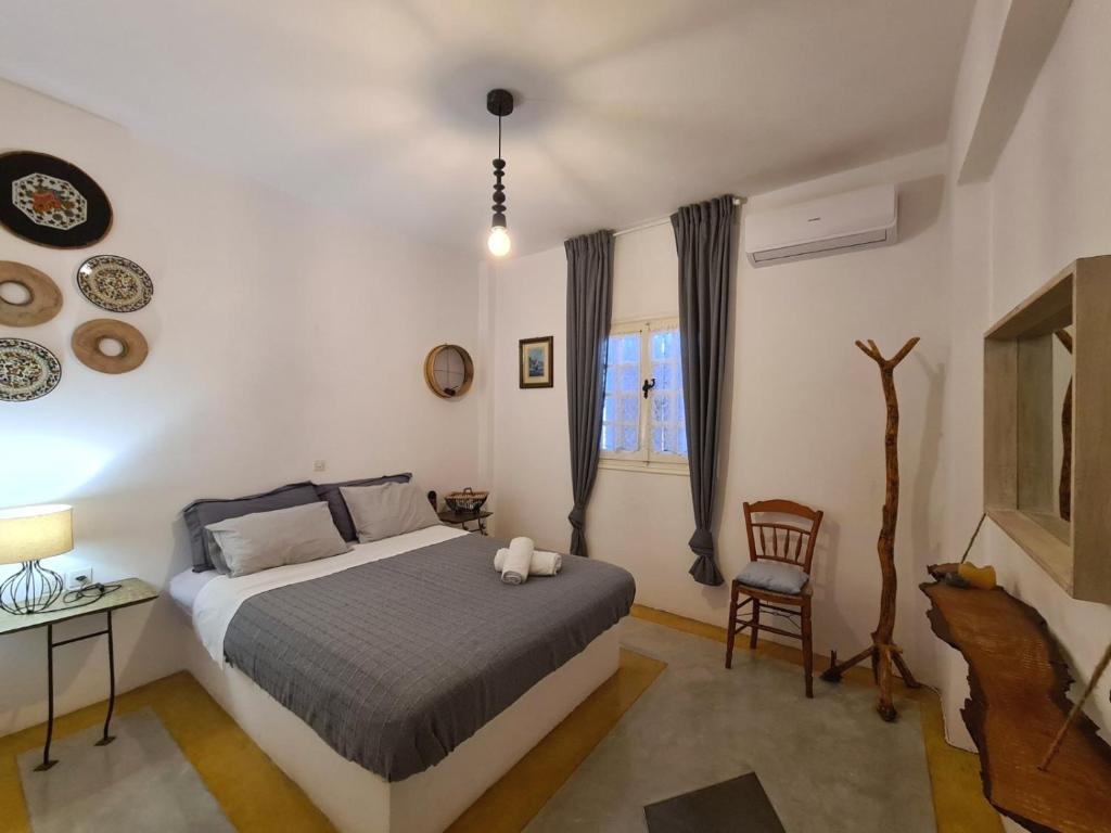 a bedroom with a bed and a chair and a window at Olive Grove Soulis Family Estate in Porto Heli