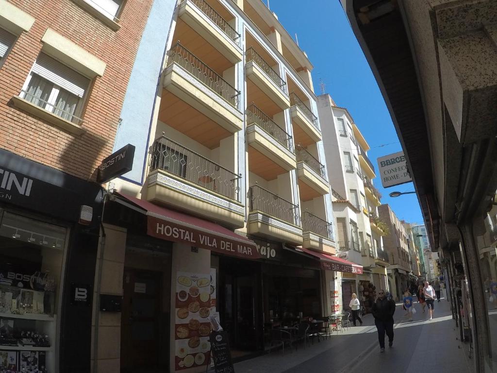 a man walking down a street in front of a building at Hostal Vila del Mar in Lloret de Mar