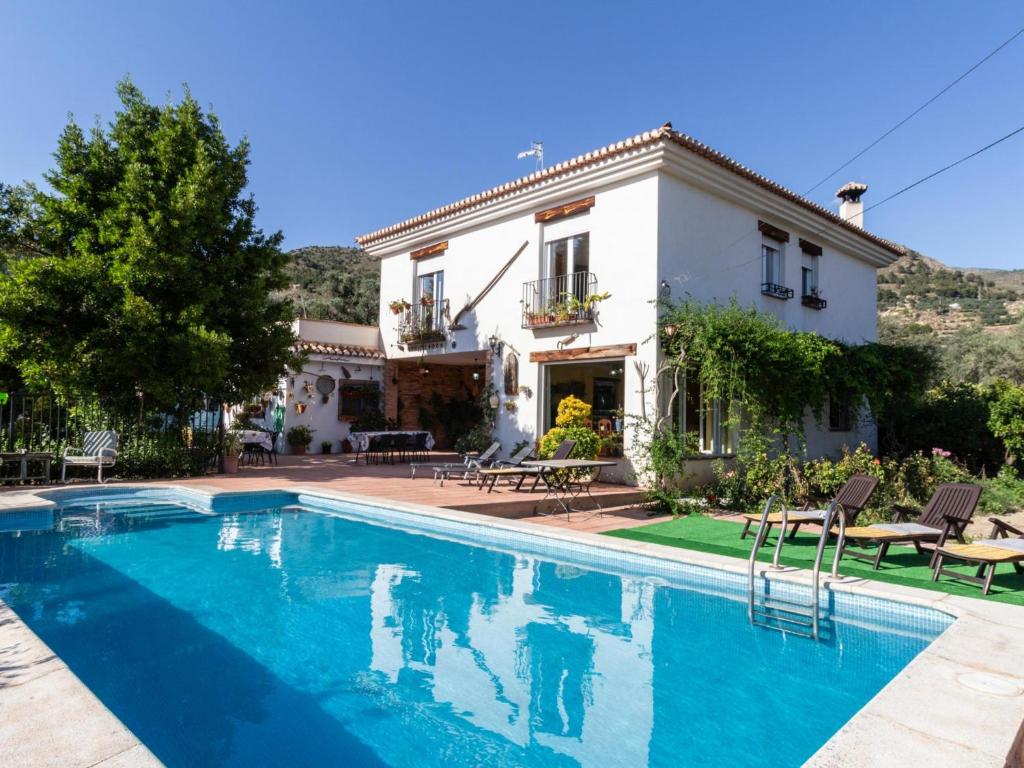 une villa avec une piscine en face d'une maison dans l'établissement Casa chico, à Béznar