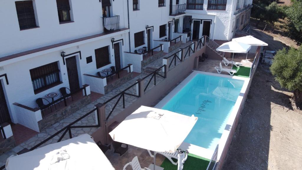 an aerial view of a building with a swimming pool and umbrellas at Apartahotel 4 vientos in Prado del Rey