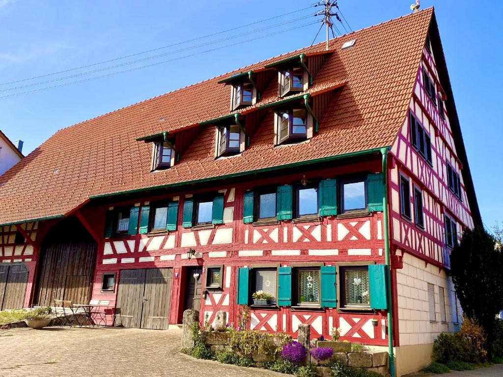 een rood-wit gebouw met een bruin dak bij Ferienwohnungen im Eugenhaus in Rosenfeld