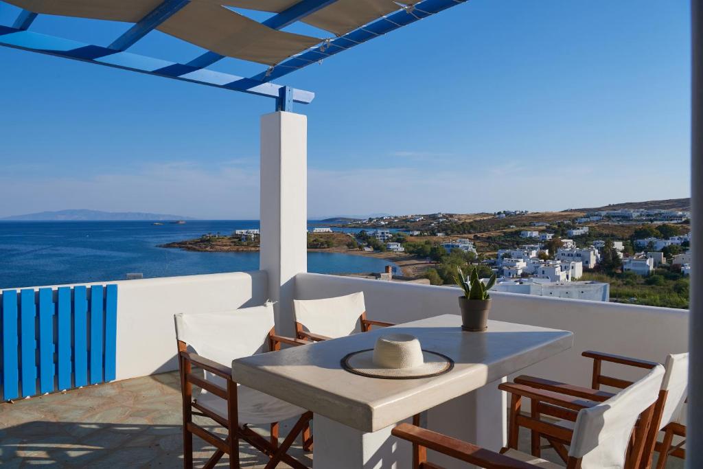 una mesa y sillas en un balcón con vistas al océano en Cleopatra Seaside Homes, Logaras, Paros, en Piso Livadi