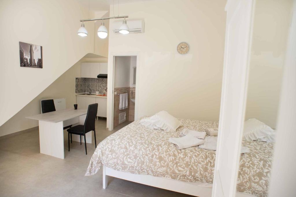 ein weißes Schlafzimmer mit einem Bett und einem Schreibtisch in der Unterkunft Isola bella in Isola delle Femmine