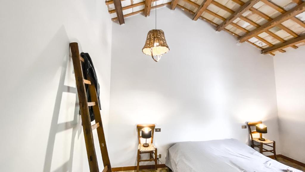 a bedroom with a bed and a ladder and a chandelier at Arte Povera Landhaus in idyllischem Naturreservat in Custonaci