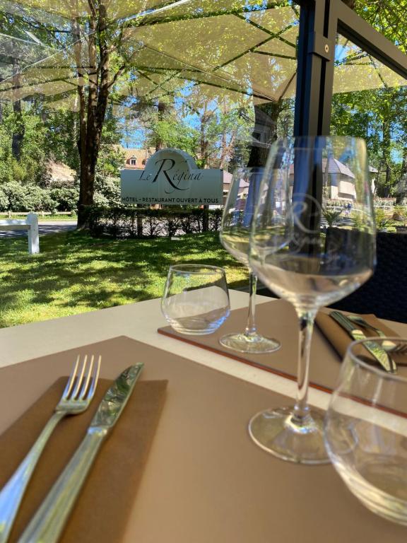 dos copas de vino sentadas en una mesa en Le Regina Hôtel restaurant en Hardelot-Plage