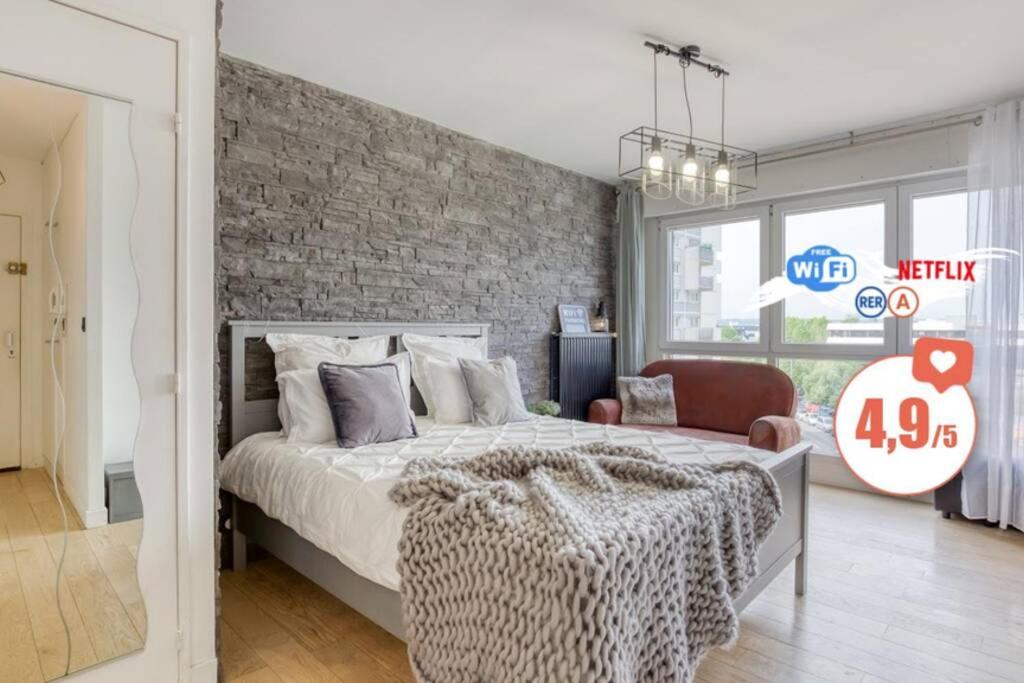 a bedroom with a large bed and a brick wall at Proche Paris - Suite Cosy - Wifi, Netflix in Chatou