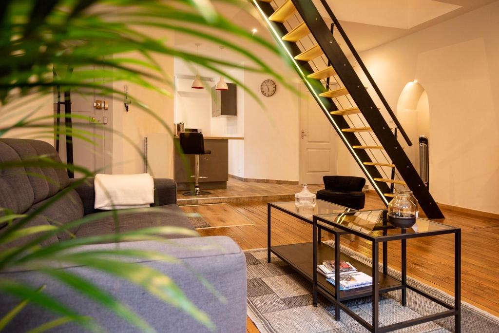 uma sala de estar com um sofá e uma escada em Chouet'appart em Dijon