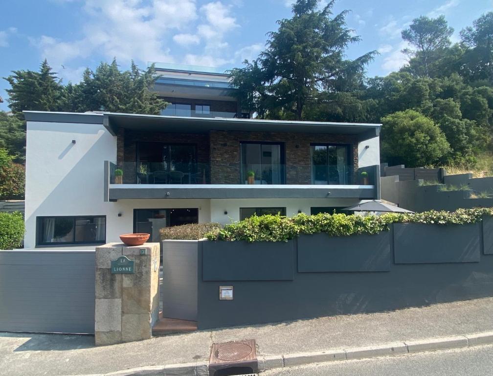 une maison blanche avec des plantes sur son côté dans l'établissement Villa de Charme La Lionne-Piscine-12 pers, à Saint-Raphaël