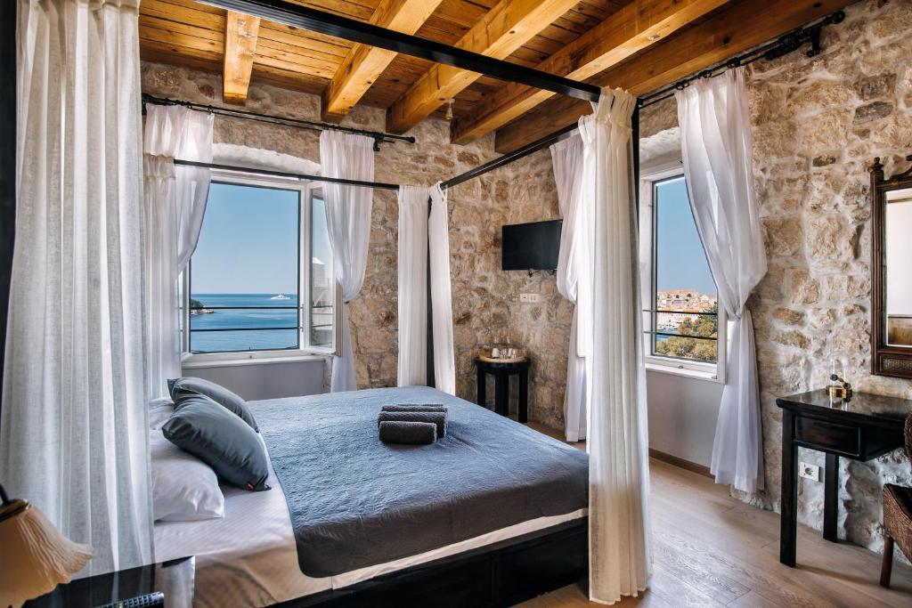 sypialnia z łóżkiem i 2 oknami w obiekcie Villa Allure of Dubrovnik w Dubrowniku