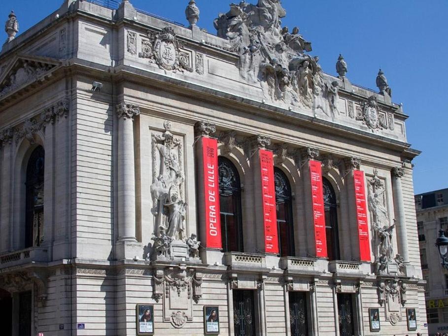 un edificio con letreros rojos en el costado. en StudioLille - Opéra, en Lille