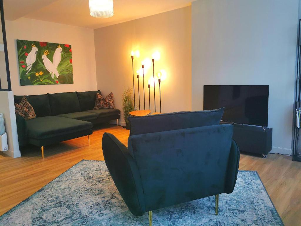 ein Wohnzimmer mit einem Sofa und einem TV in der Unterkunft Apt duplex spacieux cosy plein centre Bayeux décoration élégante proche plages du débarquement in Bayeux