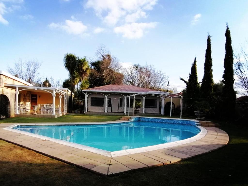 a swimming pool in the yard of a house at Casa Romana B&B in Ladybrand