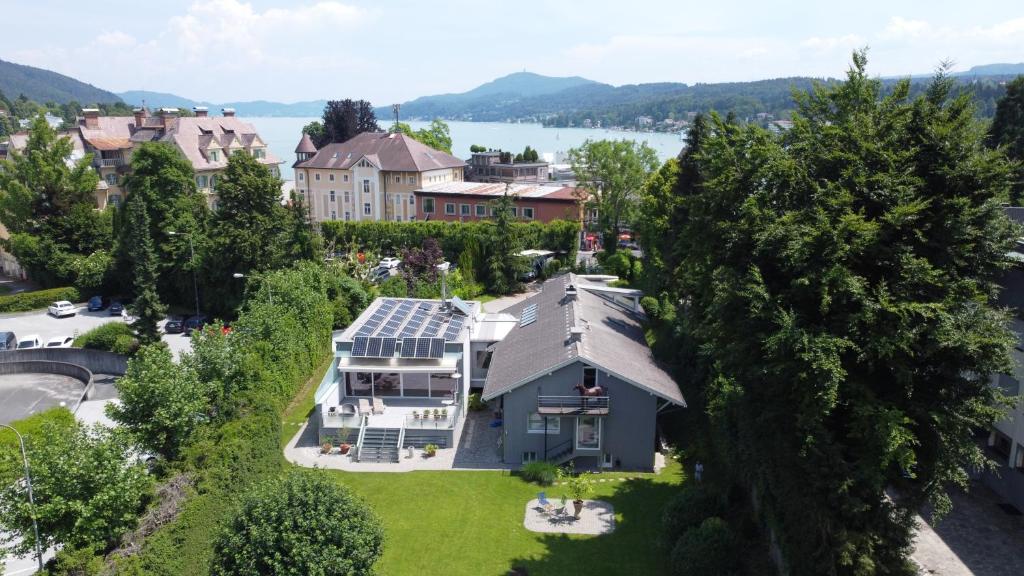 an aerial view of a house with a lake at Velden - Villa right in the center with private parking in Velden am Wörthersee