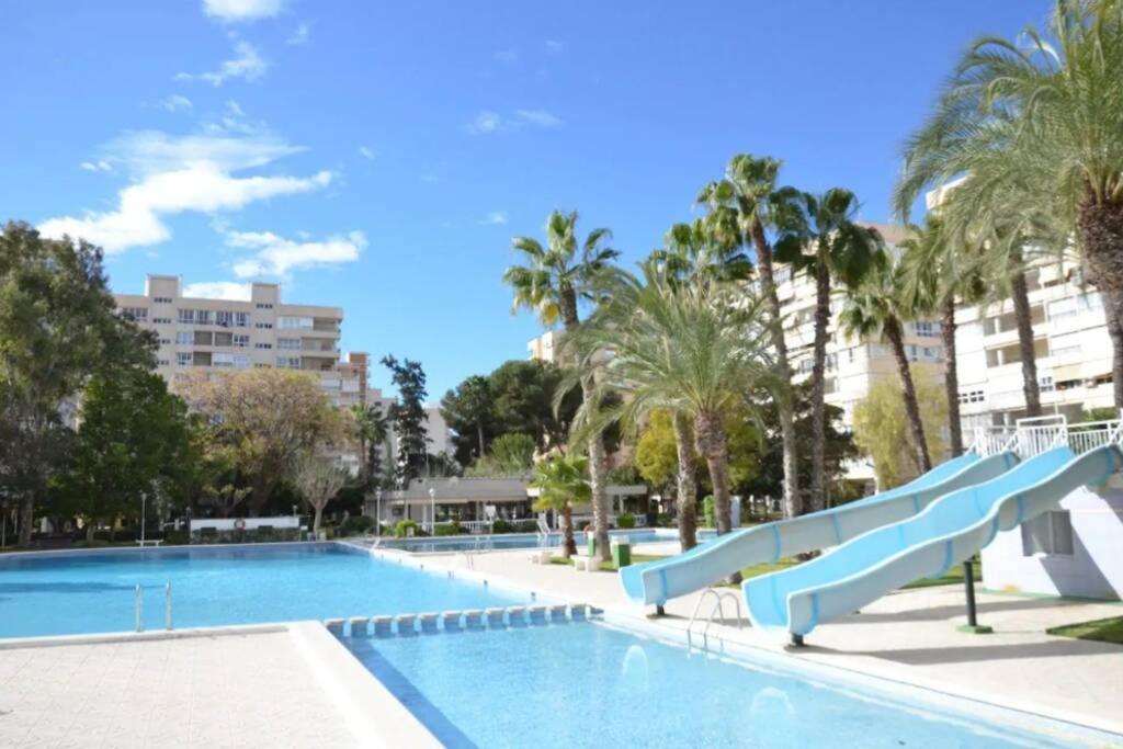 a swimming pool with a slide in a resort at Garden apartment with Pool and AC in Alicante