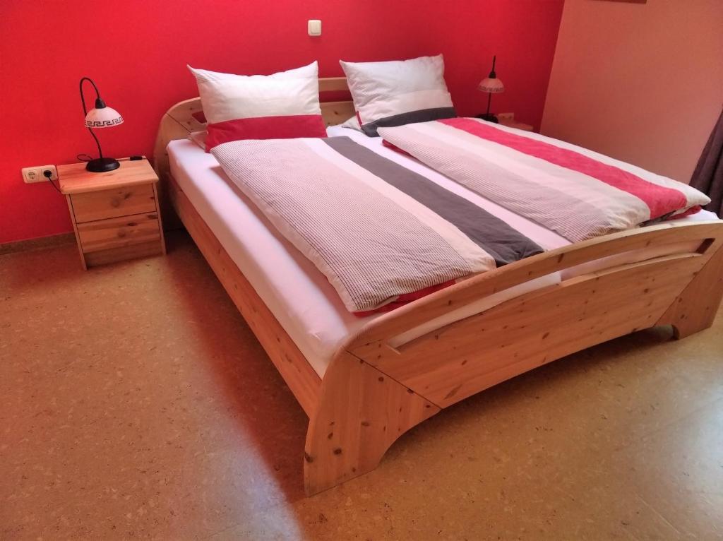 a bed with a wooden frame in a bedroom at Landhaus Aballo - Ferienwohnung in grüner Oase mit Ruhe und Komfort in Utarp