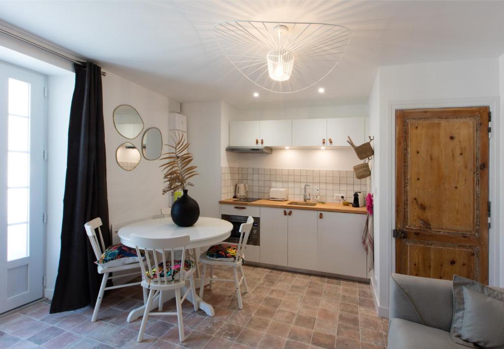 une cuisine avec une table et des chaises dans une pièce dans l'établissement Les Apparts de Charly-Superbe duplex dans un hotel particulier, parking privé gratuit, à La Rochelle