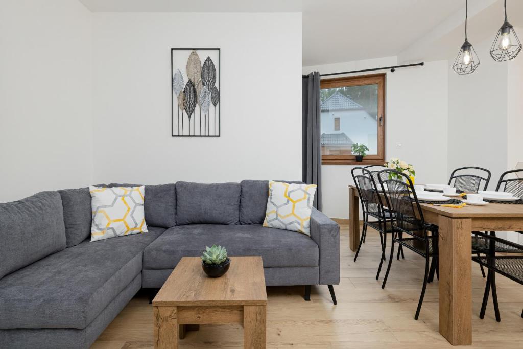 a living room with a couch and a table at Apartamenty Zielona 11 by Renters in Międzywodzie