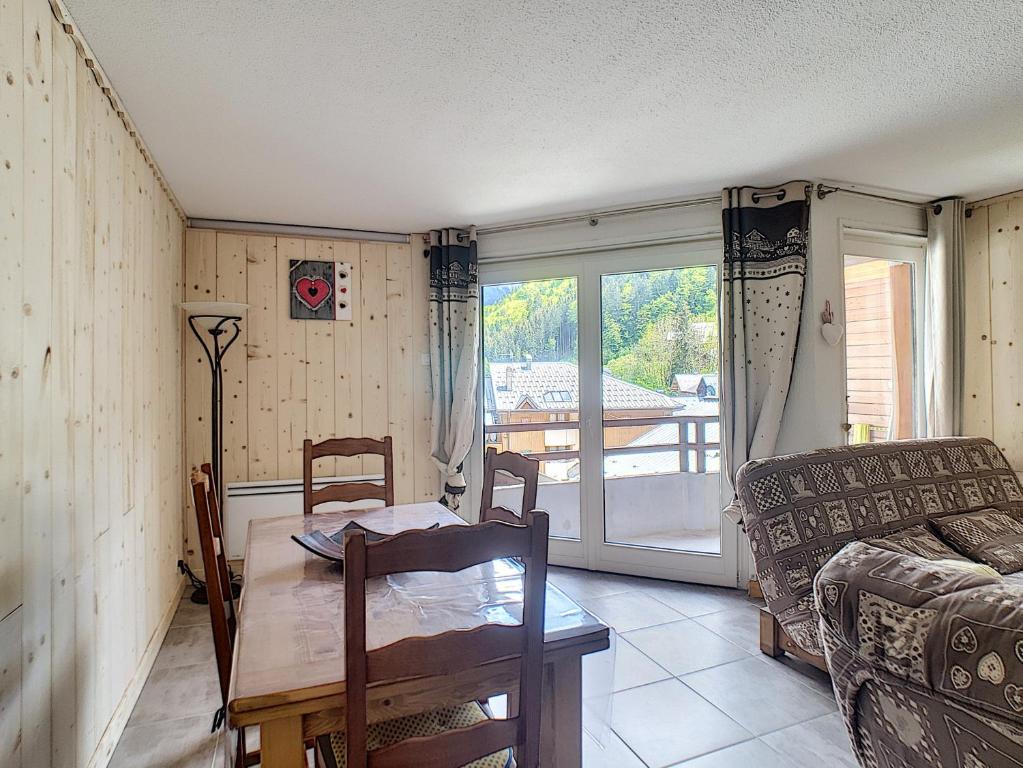ein Wohnzimmer mit einem Tisch und einem Sofa in der Unterkunft APPARTEMENT DUPLEX SPACIEUX - SAINT JEAN D'AULPS STATION - PIED DES PISTES - 9 Personnes - RELAIS D13 in Saint-Jean-dʼAulps